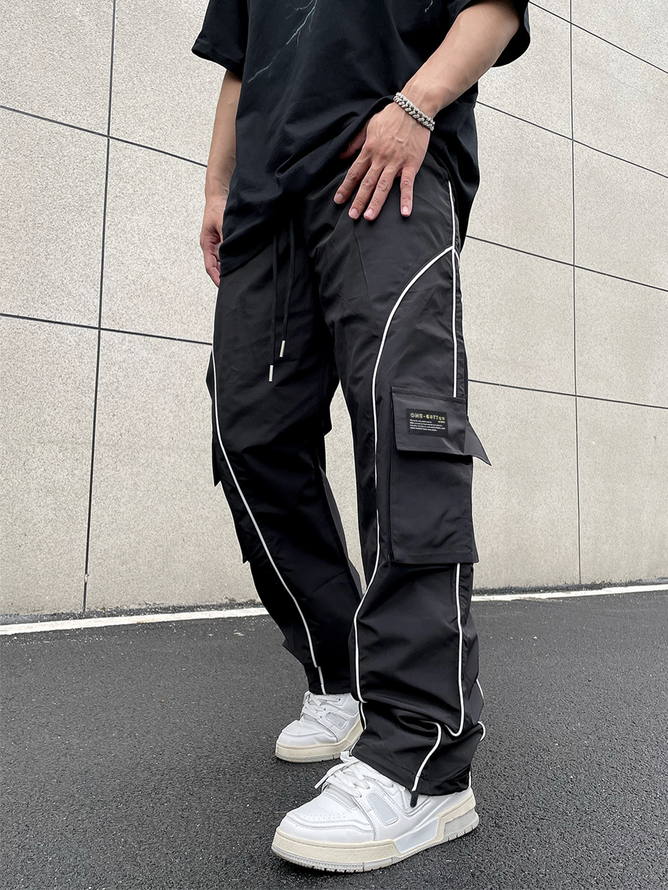Pantalones cargo TECCULI Manfinity EMRG con parche reflectante para hombre, holgados, largos, negros lisos, para salir, estilo urbano, Hypemode, para la vuelta al cole.